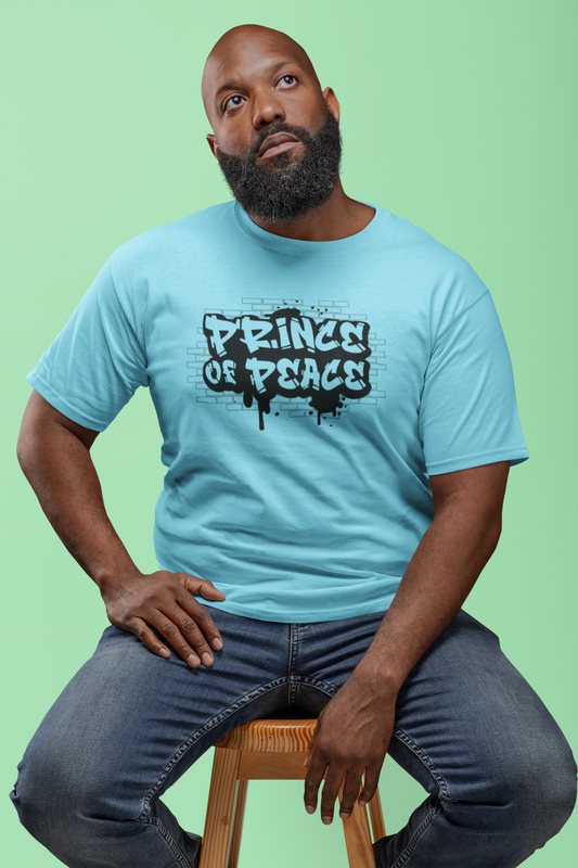 A Man seating on a stool, wearing a blue shirt with a black graffiti design that  says: Price of Peace, from the bible verse Isaiah 9: 6-7